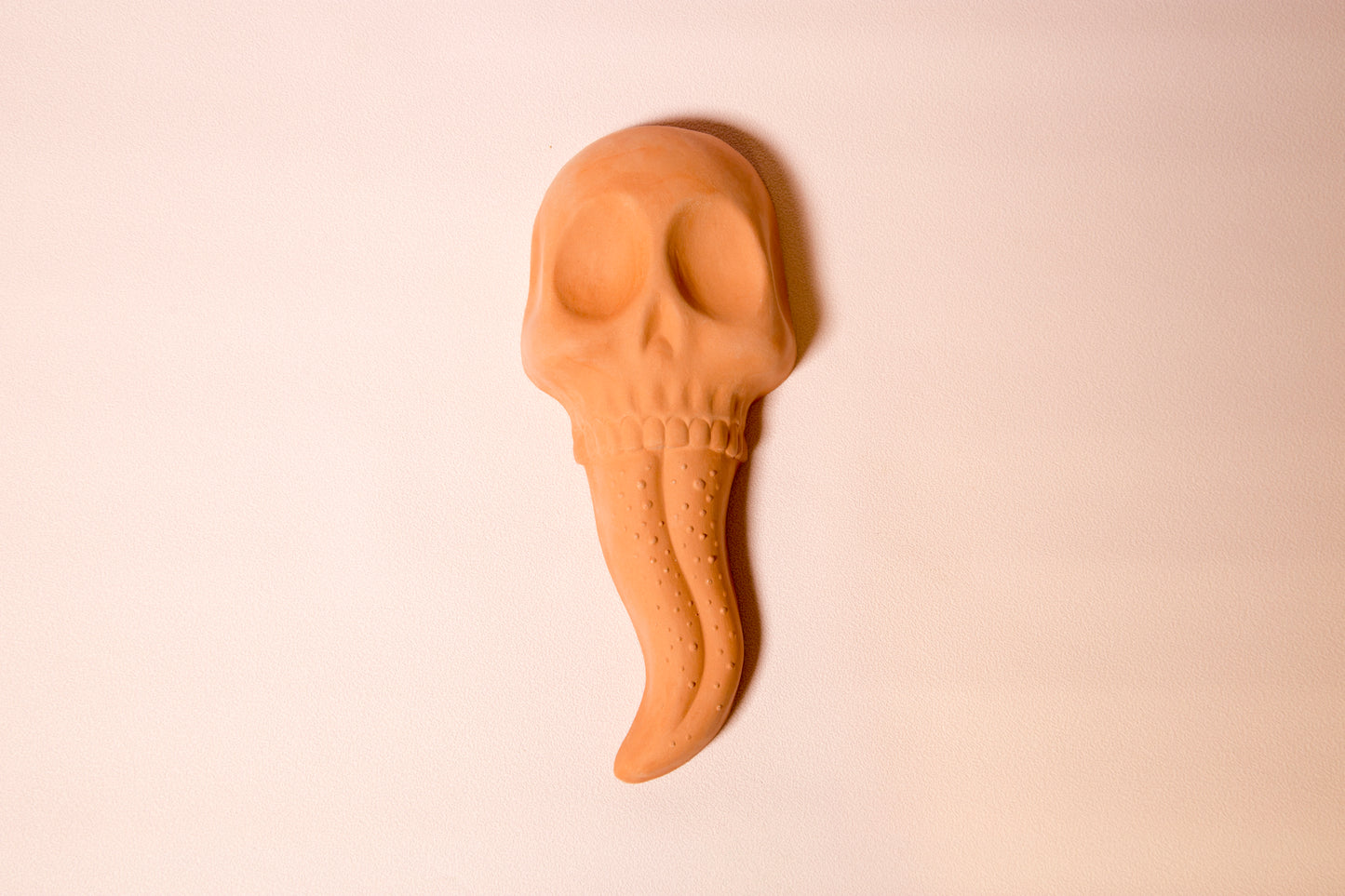Terracotta skull tongue wall ornament